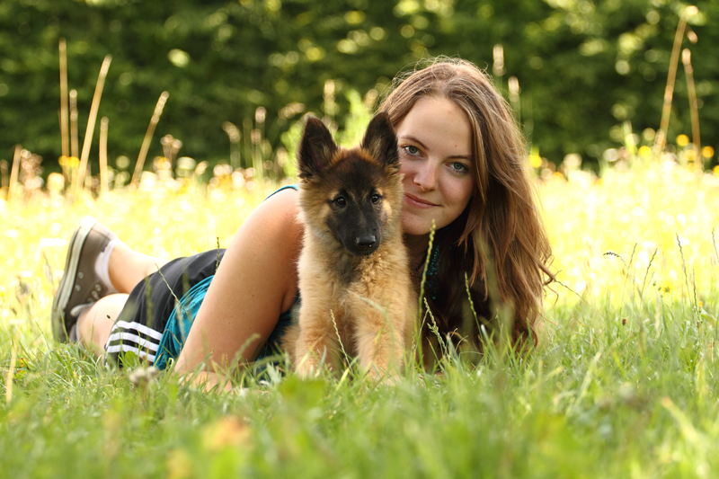 Eine Frau und ein Belgischer Schäferhund Welpe.